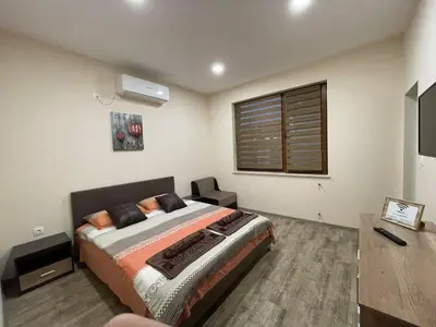 a bedroom with a bed and a television in it at Guest House Marchini in Sapareva Banya