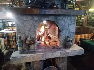 a stone oven with a fire in it at КръчмЪ При Байката in Ribarica