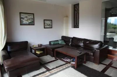 a living room with a leather couch and a table at Ski & Spa Chalet Bansko in Bansko