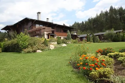 a house with a yard with flowers in front of it at Ski & Spa Chalet Bansko in Bansko