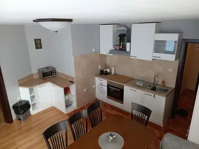 a kitchen with white cabinets and a table and chairs at Dobi's Apartment Elit47 at Elit Pamporovo in Pamporovo
