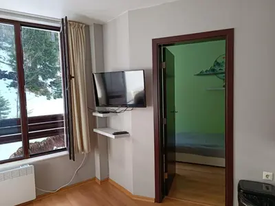 a room with a flat screen tv and a window at Dobi's Apartment Elit47 at Elit Pamporovo in Pamporovo