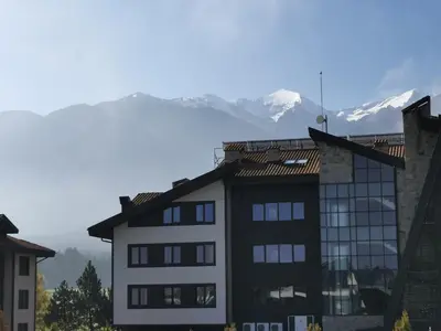 a building with a mountain in the background at Na planina in Razlog