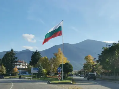 a flag on a pole in the middle of a street at Na planina in Razlog