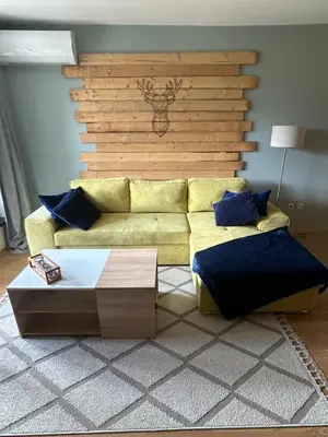 a living room with a yellow couch and blue pillows at Na planina in Razlog