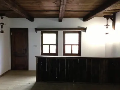 a room with two windows and a wooden wall at Ristevata Guest House in Kovachevitsa
