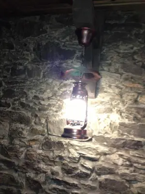 a lantern is hanging on a stone wall at Ristevata Guest House in Kovachevitsa