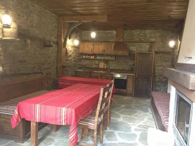 a dining room with a table and a kitchen at Ristevata Guest House in Kovachevitsa