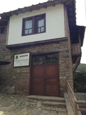a house with a wooden door and two windows at Ristevata Guest House in Kovachevitsa