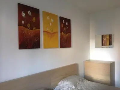 a bedroom with four paintings on the wall at Fortuna Complex Alexander Services Apartments in Bansko