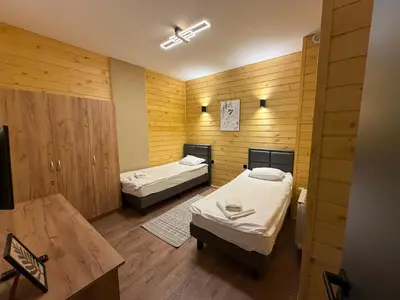 two beds in a room with wooden walls at Flora Hotel Apartment 103 in Borovets