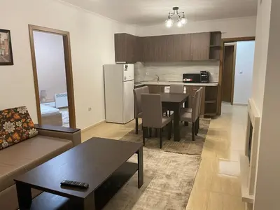 a living room with a table and a kitchen at Гранд Манастира , Пампорово in Pamporovo