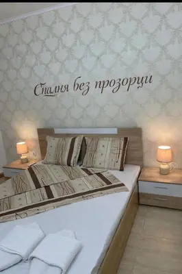a bedroom with a bed and two tables with lamps at Гранд Манастира , Пампорово in Pamporovo