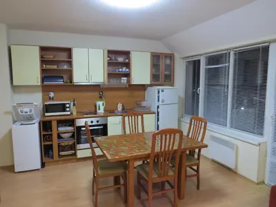 a kitchen with a table and chairs and a kitchen with white appliances at Panoramic Apartment 301 in Eagle Rock Complex in Beli Iskar