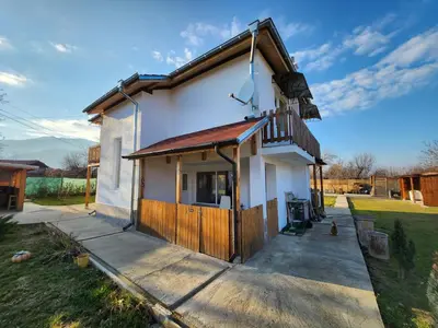 a small white house with a porch and a balcony at Villa 