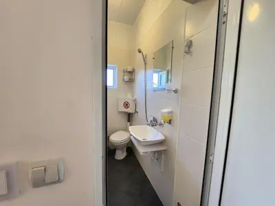 a white bathroom with a toilet and a sink at Villa 