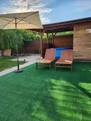 two benches sitting under an umbrella on a lawn at Villa 