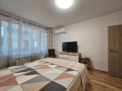 a bedroom with a bed and a flat screen tv at Brand new apartment with free parking near city center in Sofia