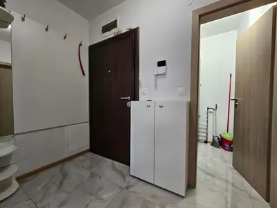 a kitchen with a refrigerator and a door in a room at Brand new apartment with free parking near city center in Sofia