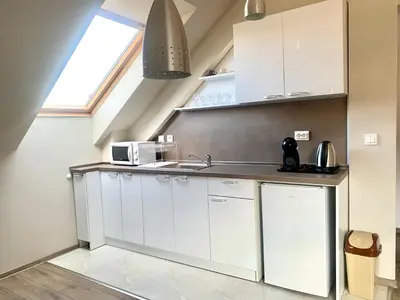 a kitchen with white cabinets and a sink at ,,Адела”-апартамент за гости in Velingrad