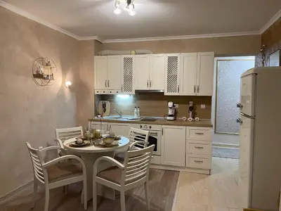 a kitchen with a table and chairs and a refrigerator at Grand Monastery Deluxe Pamporovo 5 B 3 in Pamporovo