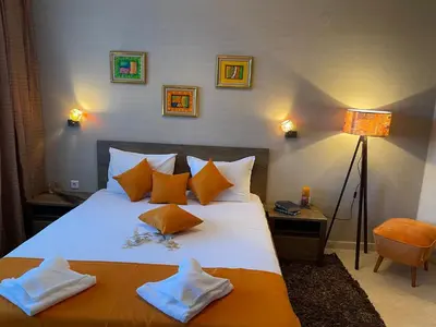 a bedroom with a large white bed with orange pillows at Grand Monastery Deluxe Pamporovo 5 B 3 in Pamporovo