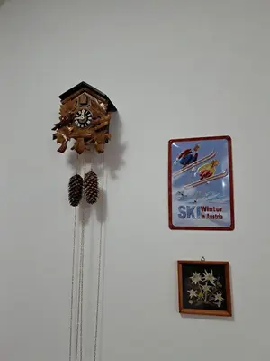 a clock hanging on a wall next to a picture at Winslow Highland Bansko - Apartment Giovanni, ул Валевица 7 кв Грамадето in Bansko