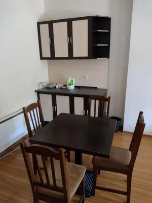 a dining room with a black table and chairs at Стаи и апартаменти под наем in Borovets