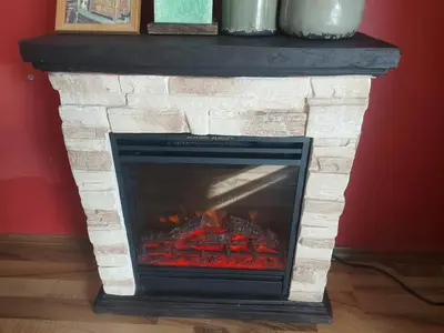 a stone fireplace with a fire in it at 1 Bedroom cozy flat in Pamporovo