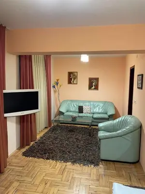 a living room with a green couch and a flat screen tv at Venis House in Plovdiv