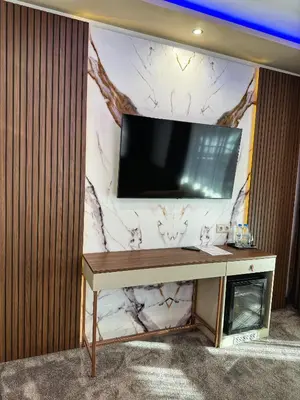 a living room with a tv on a wall at Hotel Diamant in Dospat