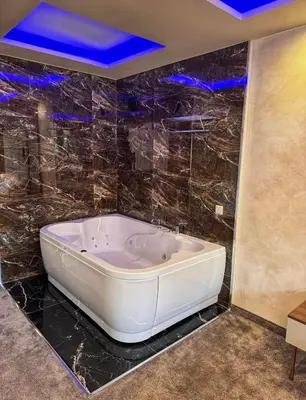 a large bath tub in a bathroom with blue lights at Hotel Diamant in Dospat