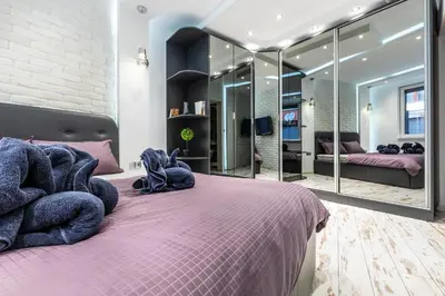 a bedroom with a purple bed with a large mirror at Modern 1BD Flat with a Parking near the city centre by Flat Mаnager in Plovdiv