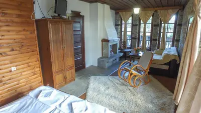 a living room with a chair and a fireplace at Leshtenski Rai Guest House in Leshten