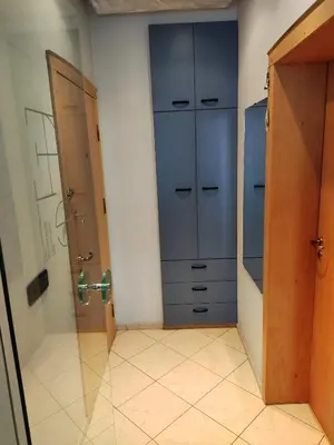 a bathroom with blue cabinets and a tiled floor at Rila Apartment in Samokov