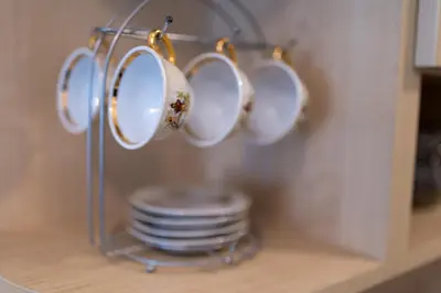 a rack of cups and plates on a shelf at Karastoyanovi's Apartment in Sofia