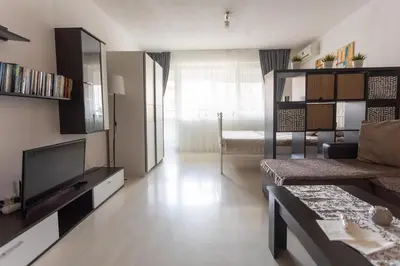 a living room with a couch and a television at Karastoyanovi's Apartment in Sofia