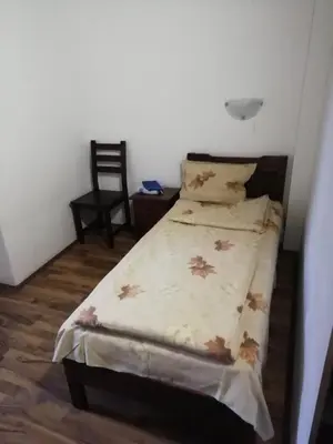 a bed in a small room with a chair and a bedspread at ХАН КОСТИНА - HAN KOSTINA in Ribarica