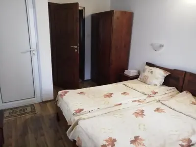 a bedroom with a bed with a comforter on it at ХАН КОСТИНА - HAN KOSTINA in Ribarica