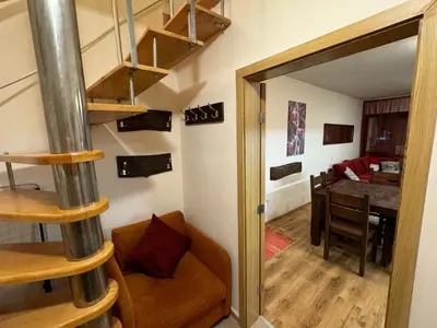 a room with a spiral staircase and a dining room at Bansko Ski to Door Apartment in Bansko