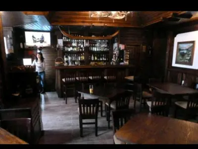 a woman standing in a restaurant with tables and chairs at Bansko ski apartment Mountain View Resort in Bansko