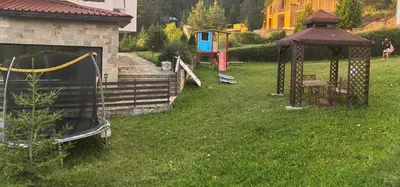 a playground in a yard with a gazebo at Тайната квартира - The Secret apartment in Pamporovo