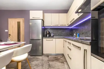 a kitchen with white cabinets and a stainless steel refrigerator at Stylish 1BD flat with a Parking Spot by Flat Mаnager in Plovdiv