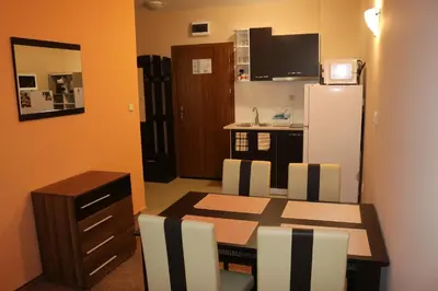 a dining room with a table and a refrigerator at Winter Аpartments Gerovi in Pamporovo
