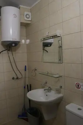 a bathroom with a sink and a mirror and a toilet at Winter Аpartments Gerovi in Pamporovo