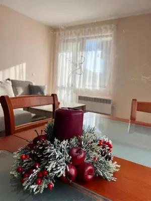 a table with a christmas wreath and a candle on it at Prime Apartments in Bansko