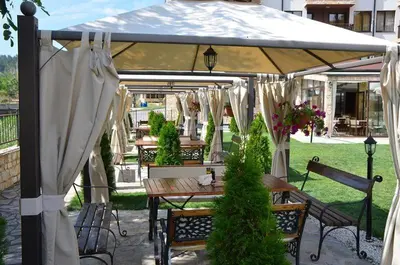 a patio with a table and an umbrella at Апартамент Лукс в Спа Хотел Свети Спас in Velingrad