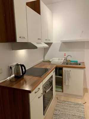 a kitchen with white cabinets and a counter top at Premium Apartments Bansko in Bansko