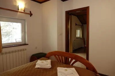 a dining room with a table and a window at Семеен хотел Орфей in Teshel