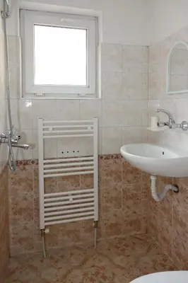 a bathroom with a sink and a tub and a window at Семеен хотел Орфей in Teshel